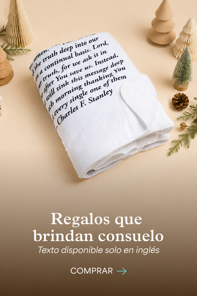 Una manta blanca doblada con una oración de Charles F. Stanley impresa, rodeada de arbolitos navideños de papel. Regalos que brindan consuelo. Texto disponible solo en inglés. Comprar.